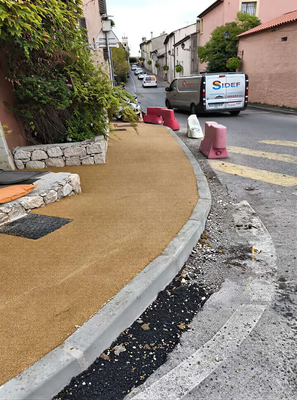Cheminement pieton en revetement drainant clair, bordures pierre et enrobe noir cote chaussee